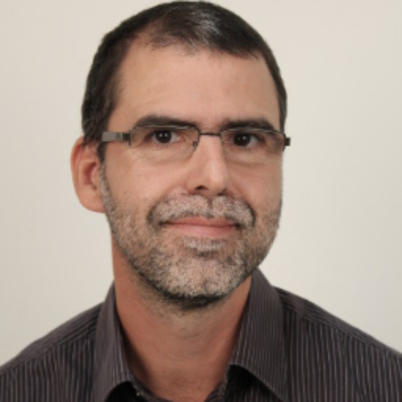 Homme brun avec des lunettes et une barbe grisonante